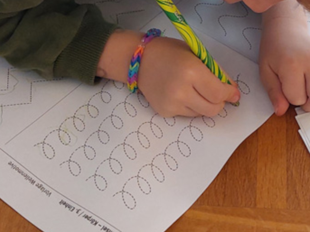 Foto Kinderhand beim Wellenspuren